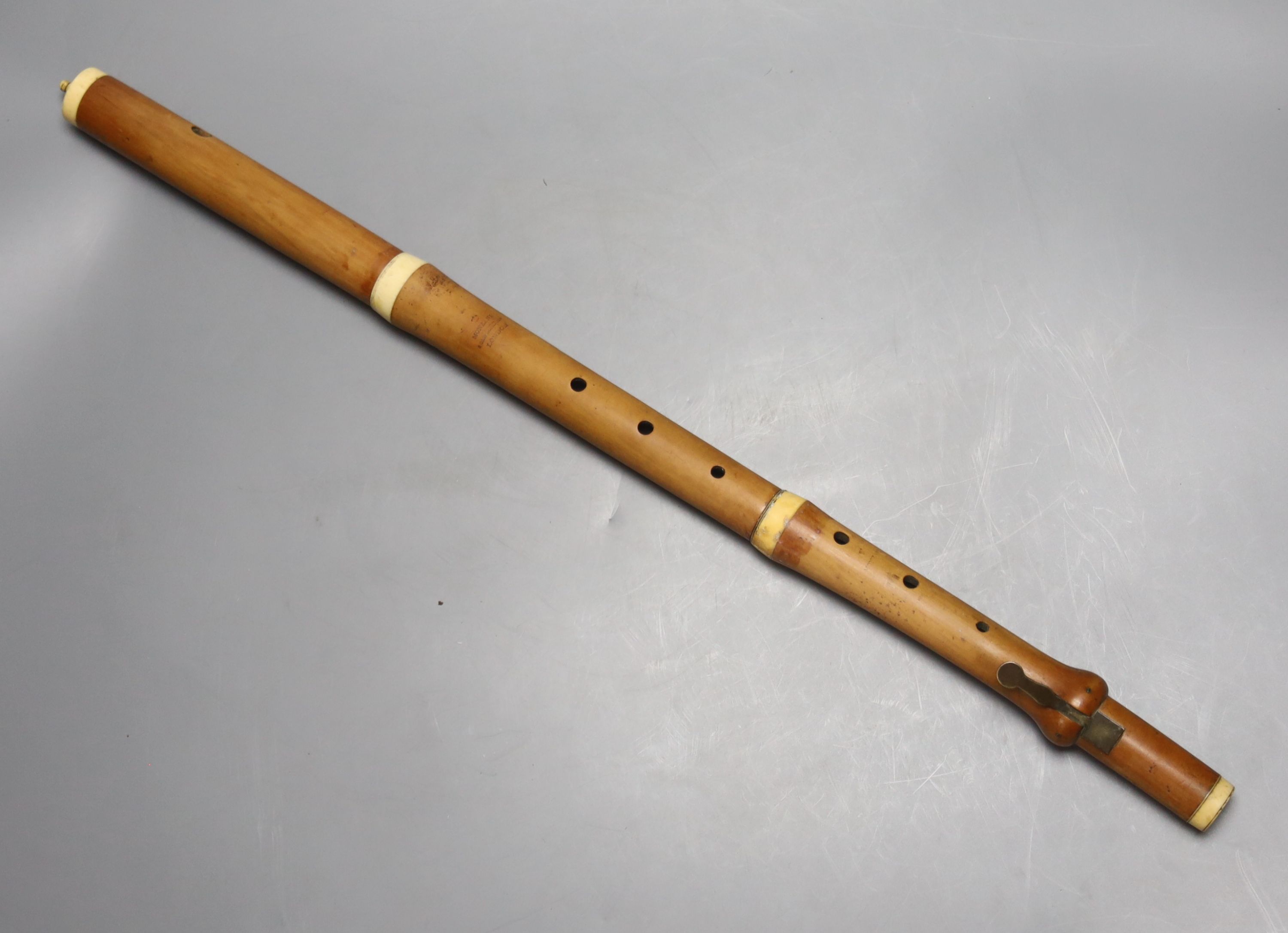 A three sectional Monzani flute with seven holes and a turned ivory cap and collars, stamped Monzari, Old Bona St , London, 19th centur